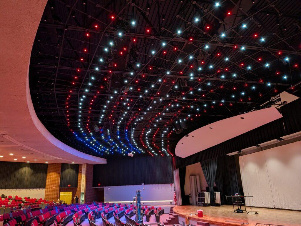 Glendive Auditorium featuring dynamic red, blue, and white PoE-powered LED ceiling lighting